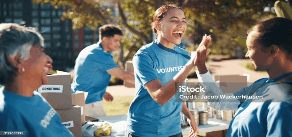 Volunteers smiling and cheering each other on at volunteer event