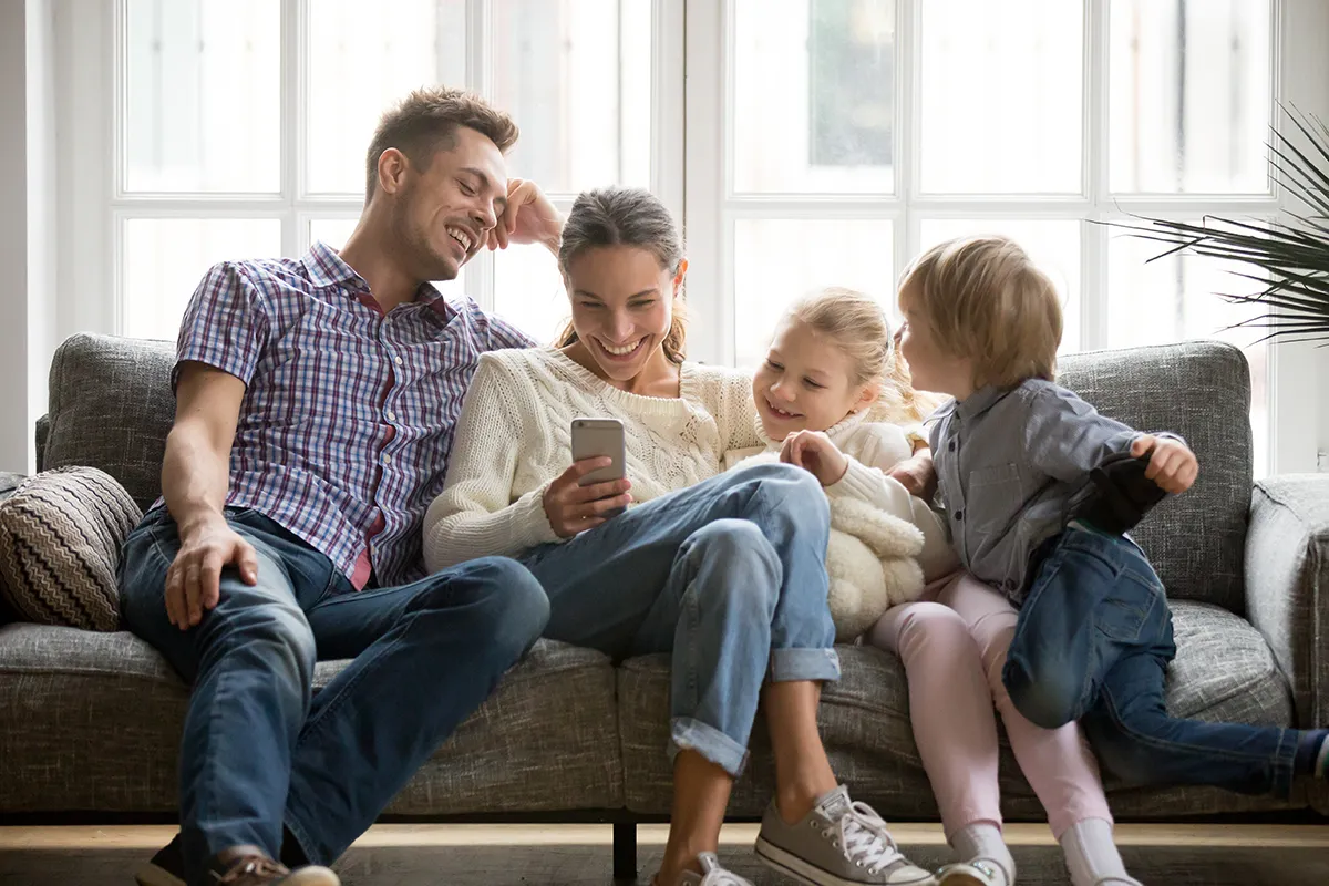 Family on Sofa looking at a phone.