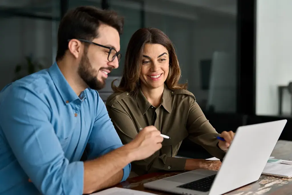 Man and woman looking at results on a laptop.